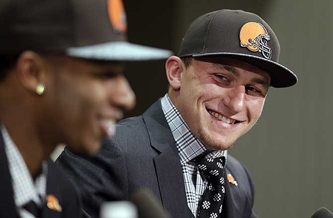 Cleveland Browns quarterback Johnny Manziel, right, from Texas A&M, watches cornerback Justin Gilbert during their introductory news conference at the NFL football team's facility in Berea, Ohio Friday, May 9, 2014. The Browns selected Gilbert with the eighth pick and Manziel with the 22nd pick in the first round of Thursday night's draft. 