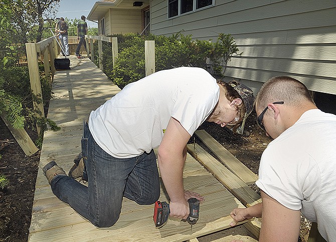 Colton Henley drives the screws through wooden planks as fellow student Zack Fischer holds them in place. Both are seniors involved in Nichols Career Center's Building Trades Class, which is a cooperative project between the class and Habitat for Humanity. 