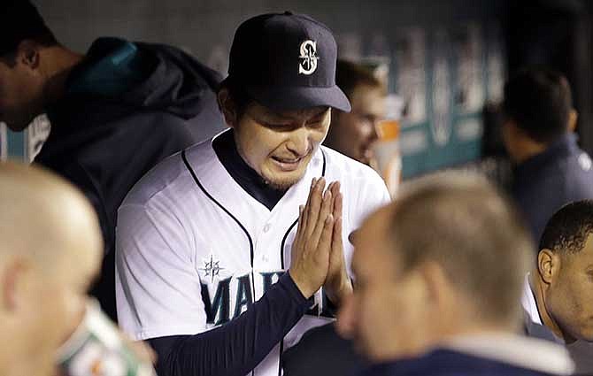 Seattle Mariners starting pitcher Hisashi Iwakuma bows to a teammate in the dugout after coming out of the game against the Kansas City Royals after the eighth inning of a baseball game Thursday, May 8, 2014, in Seattle. 