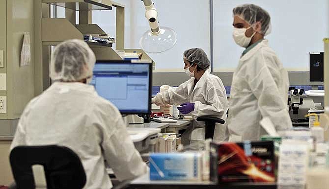 In this April 15, 2014 photo, criminalist trainees work at a lab in the Office of Chief Medical Examiner in New York. With new technology yielding results impossible a dozen years ago, forensic scientists are still trying to match the bone with DNA from those who died on Sept. 11, 2001, and have never been identified.