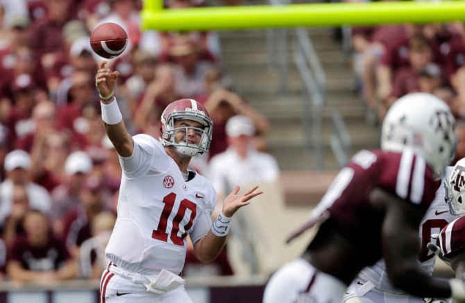 In this Sept. 14, 2013, file photo, Alabama quarterback AJ McCarron (10) throws a pass against Texas A&M during the second quarter of an NCAA college football game in College Station, Texas. McCarron was selected by the Cincinnati Bengals in the fifth round, 164th overall, in the 2014 NFL Draft on Saturday, May 10, 2014.