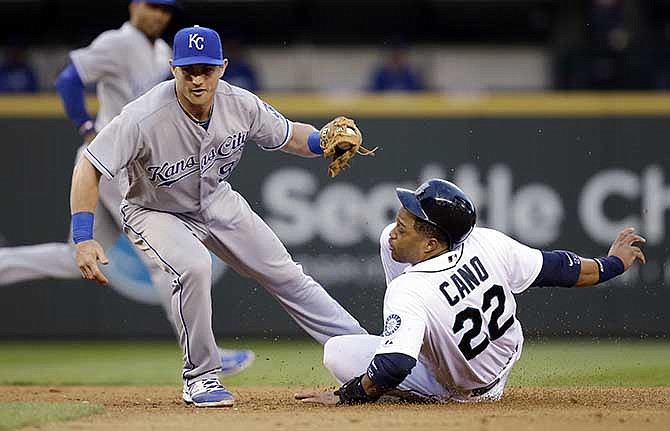 Kansas City Royals second baseman Johnny Giavotella, left, comes up from his tag of Seattle Mariners' Robinson Cano on an attempted stolen base at second base in the seventh inning of a baseball game Saturday, May 10, 2014, in Seattle. Cano was initially ruled safe, but the call was changed after a review.