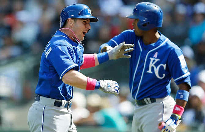 Kansas City Royals' Johnny Giavotella, left, is greeted by Royals' Alcides Escobar, right, after Giavotella hit a three-run home run in the seventh inning of a baseball game against the Seattle Mariners, Sunday, May 11, 2014 in Seattle.