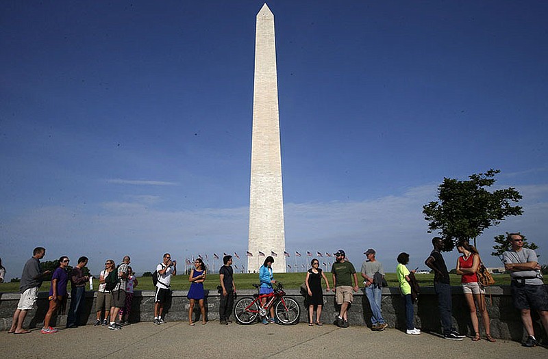 Visitors line up for tickets which are distributed at on a first-come basis at the Washington Monument ahead of a ceremony to celebrate its re-opening. 