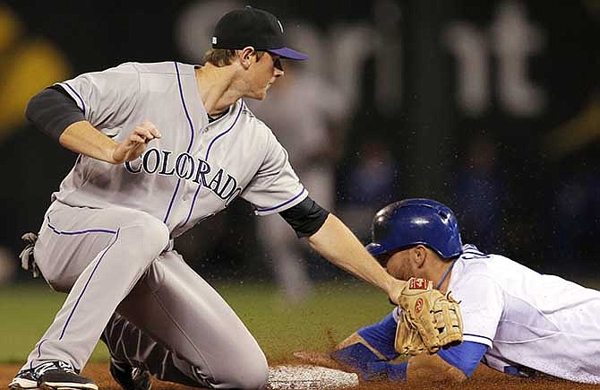 Kansas City Royals' Alex Gordon, right, beats the tag by Colorado Rockies second baseman DJ Lemahieu, left, during the fifth inning of a baseball game at Kauffman Stadium in Kansas City, Mo., Tuesday, May 13, 2014. Gordon was safe with a stolen base on the play. 