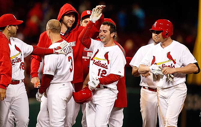 St. Louis Cardinals' celebrate their twelfth inning walk off victory against the Chicago Cubs after Greg Garcia (12) was hit by a pitch resulting in the winning run scoring Tuesday, May 13, 2014, in St. Louis. 