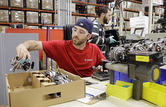 In this April 15, 2014 photo, Anthony Zingale wires blender motors at the Vitamix manufacturing facility in Strongsville, Ohio. The Labor Department releases the Producer Price Index for April on Wednesday, May 14, 2014.