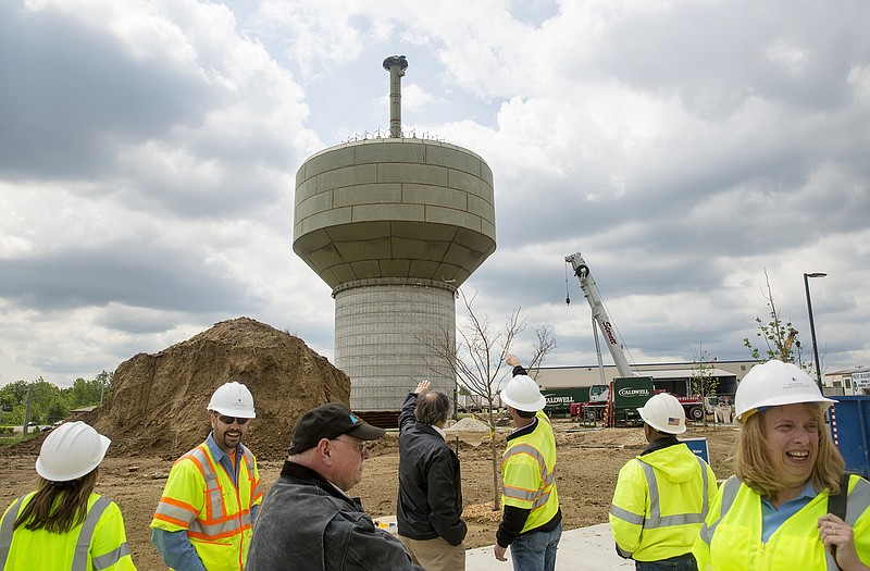 Observers wear fluorescent vests and hard hats while watching workers raise the steel tank to the top of the new 1.5 million gallon water tower off of Rock Hill Road Thursday morning behind the new fire station. The tank is being built by Missouri American Water to help with water pressure throughout Jefferson City and to increase flow for fighting fires. Completion of the tank is expected this fall. 