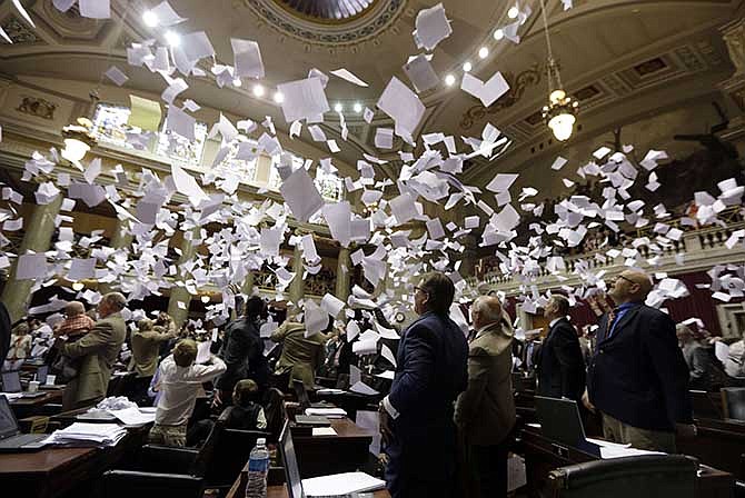 Members of the Missouri House of Representatives throw papers in the air in celebration of the end of the legislative session Friday, May 16, 2014, in Jefferson City, Mo. 