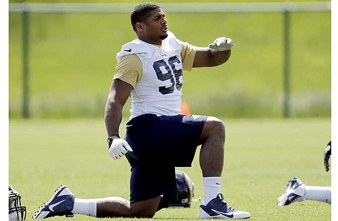 St. Louis Rams rookie defensive end Michael Sam stretches during the team's NFL football rookie camp Friday, May 16, 2014, in St. Louis.