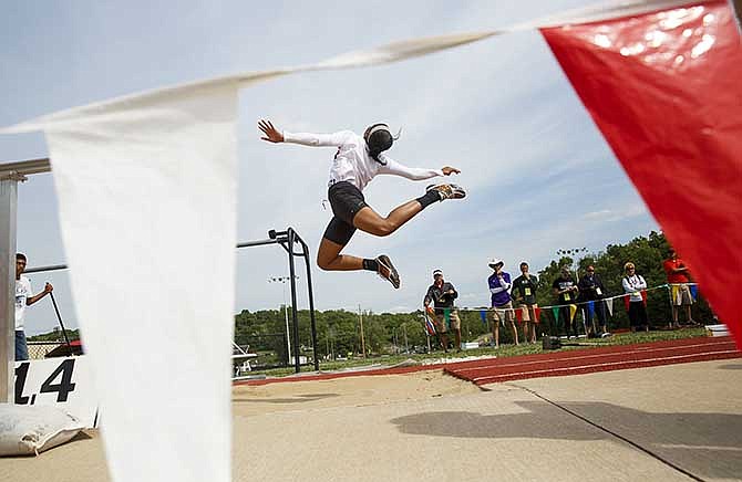 Kezia Martin of Jefferson City flies toward the sand during the girl's long jump finals Saturday at the Class 4 District 5 meet at Adkins Stadium.