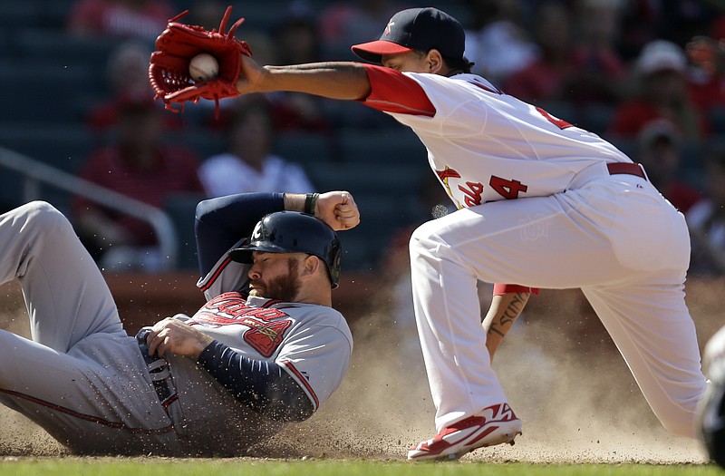 Ryan Doumit of the Braves scores on a wild pitch as Cardinals reliever Carlos Martinez covers home during the ninth inning of Sunday afternoon's game at Busch Stadium.