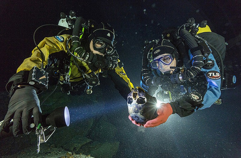 Divers Alberto Nava and Susan Bird transport the Hoyo Negro skull to an underwater turntable so that it can be photographed to create a 3-D model in an underwater cave in Mexico's Yucatan Peninsula.