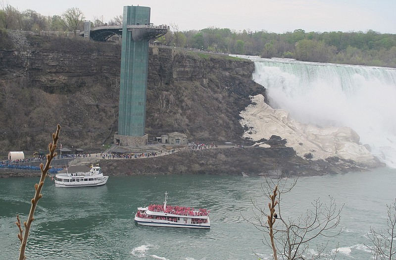 A Hornblower Niagara Cruises catamaran sails back to its Canadian dock as passengers in blue ponchos line up at the American dock in Niagara Falls, N.Y., to board the Maid of the Mist. Until this year, the Maid of the Mist operated cruises from both sides of the river, but lost its Canadian contract to San Francisco-based Hornblower Co. 
