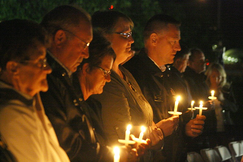 Attendees hold candles during a service at the Missouri Firefighters Memorial in Kingdom City on Saturday to honor fallen firefighters from the state. 