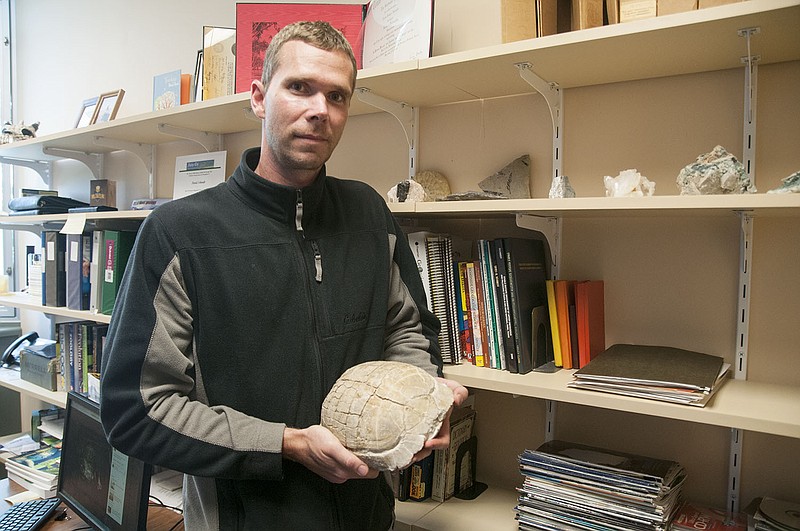 David Schmidt, environmental sciences professor at Westminster College, holds Gary, a 32 million-year-old tortoise shell in his office on Friday. The shell is the subject of Schmidt's student, Meredith Bolen, who will be a junior in the fall.