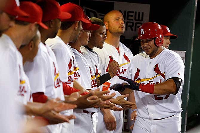 St. Louis Cardinals' Jhonny Peralta, right, is congratulated by teammates in the dugout after hitting a solo home run during the sixth inning of a baseball game against the Arizona Diamondbacks Tuesday, May 20, 2014, in St. Louis. 