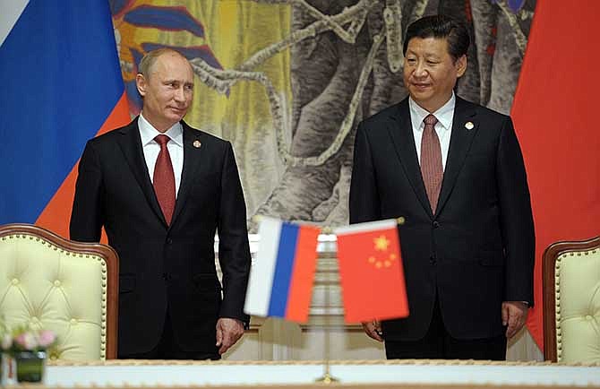 Russia's President Vladimir Putin, and China's President Xi Jinping, right, smile during signing ceremony in Shanghai, China on Wednesday, May 21, 2014. China signed a long-awaited, 30-year deal Wednesday to buy Russian natural gas worth some $400 billion in a financial and diplomatic boost to diplomatically isolated President Vladimir Putin. 