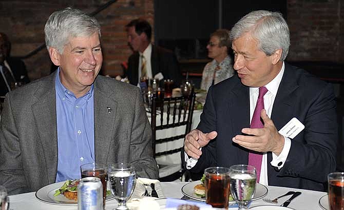 Michigan Gov. Rick Snyder, left, speaks with JP Morgan Chase Chairman and CEO Jamie Dimon at an announcement, Wednesday May 21, 2014, about Chase investing$100 million in Detroit over the next five years. (AP Photo/Detroit News, Chrles V. Tines)