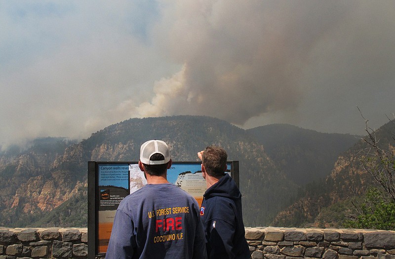 Coconino National Forest Battalion Chief Preston Mercer, left, and fire information officer Bill Morse, right, survey a fire burning in Oak Creek Canyon, Ariz., on Wednesday Hundreds of firefighters poured into northern Arizona to battle the wind-whipped blaze. 
