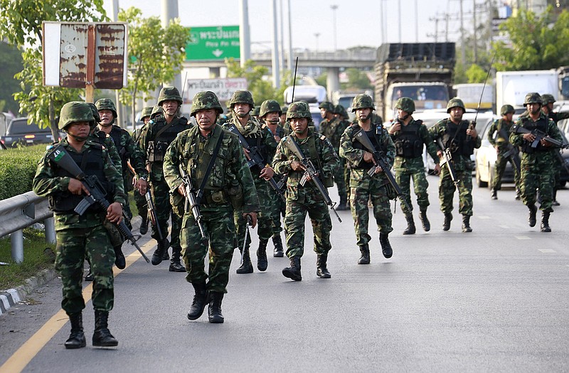 Thai soldiers move in to a pro-government demonstration site after the coup Thursday on the outskirts of Bangkok, Thailand. Thailand's new military junta has announced that it has suspended the country's constitution.