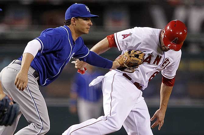 Kansas City Royals third baseman Danny Valencia, left, tags out Los Angeles Angels' David Freese in a rundown between third and second base, on a fielder's choice to the pitcher by Angel's Erick Aybar, in the 10th inning of a baseball game Saturday, May 24, 2014, in Anaheim, Calif.