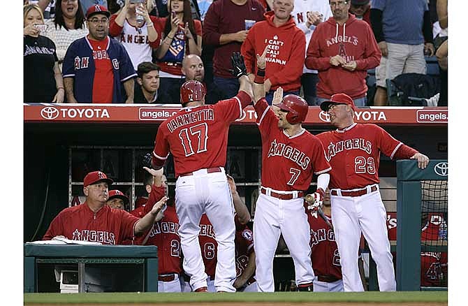 Los Angeles Angels' Chris Iannetta (17) is congratulated by teammates and coaches after hitting a home run during the second inning of a baseball game against the Kansas City Royals on Friday, May 23, 2014, in Anaheim, Calif.