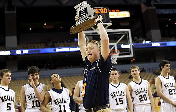 Helias senior team manager Elijah Mayfield proudly hoists the MSHSAA Class 4 third place trophy following the Crusaders' victory over Farmington at Mizzou Arena on March 22, 2014.