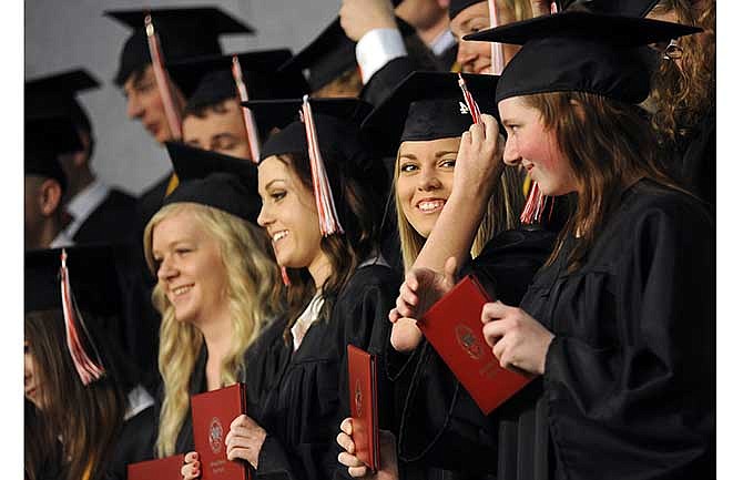 Madelyn Fisher, second from right, moves her tassel to the left side of her cap after accepting her diploma during Saturday's commencement ceremony in Jefferson City for Calvary Lutheran High School's sixth graduating class.