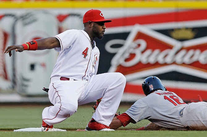 St. Louis Cardinals' Kolten Wong (16) steals second base as Cincinnati Reds second baseman Brandon Phillips (4) is late with the tag in the first inning of a baseball game, Sunday, May 25, 2014, in Cincinnati. 