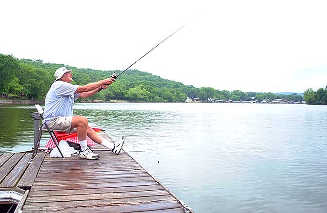 Camdenton resident Bill Christian shows why his friends call him the "cast master," landing his lure more than 100 yards out from the fishing and boat dock at Ha Ha Tonka State Park in Camdenton, Mo., on Saturday. 