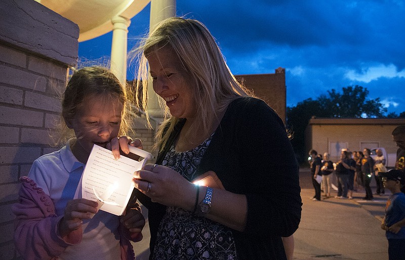 Ava Santhuff, 5, and Sarah Boycherding of Fulton block the wind from blowing out a candle Tuesday during a candlelight prayer vigil for Ava Santhuff's twin brother, "Super" Sam Santhuff who is battling to - as he has said - "kick cancer's butt." About 100 people attended to "light up Court Street" and pray for the young boy and his family, especially his sister who has remained a major source of strength for him. He is being treated at St. Louis Children's Hospital in St. Louis. Anyone interested in supporting "Super" Sam can go to the Facebook page, "SuperSam's Heroes."