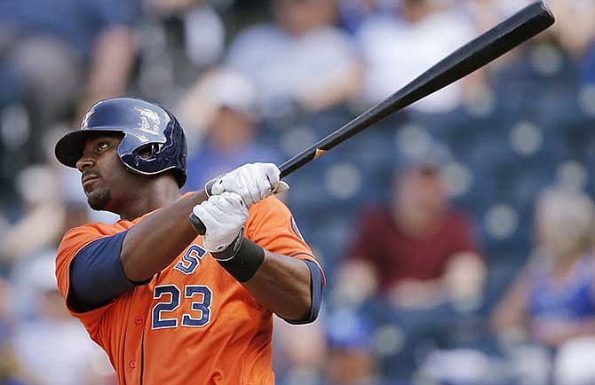 Houston Astros' Chris Carter follows through on a three-run home run off Kansas City Royals relief pitcher Louis Coleman during the sixth inning of a baseball game at Kauffman Stadium in Kansas City, Mo., Wednesday, May 28, 2014.