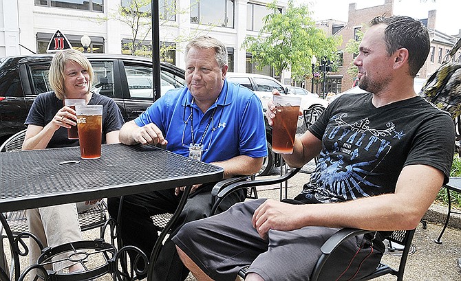 Mike Liebler, right, visits with Vince and Jana Owens as they wait for lunch Wednesday before Liebler heads back out on his bicycle to continue his westward journey. He's cycling from Connecticut to San Francisco, but has had a several-day layover in Jefferson City. 