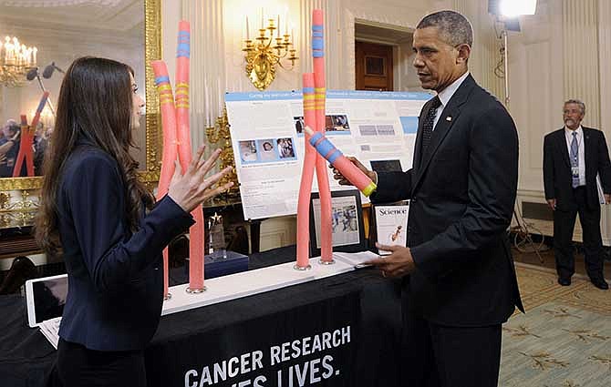 President Barack Obama talks with Elana Simon, 18, of New York City, about her cancer research project that is part of the 2014 White House Science Fair exhibit on display in the State Dining Room of the White House in Washington, Tuesday, May 27, 2014. Simon, at age 12, was diagnosed with fibrolamellar hepatocellular carcinoma, a little-known form of cancer that affects the liver. After surviving the disease, she now helps scientists research the genetics behind it. Obama was celebrating the student winners of a broad range of science, technology, engineering and math (STEM) competitions from across the country.