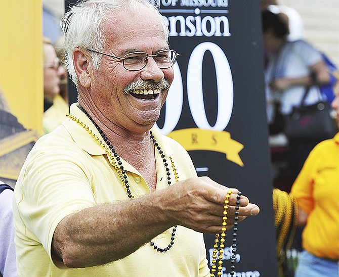 Tony Delong of the University of Missouri Extension Service hands out strands of black and gold beads during the annual Missouri State Employee Recognition Day Thursday. 