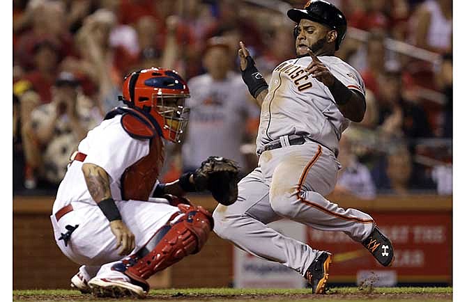 San Francisco Giants' Pablo Sandoval, right, scores on a two-run double by Michael Morse as St. Louis Cardinals catcher Yadier Molina looks for the throw during the eighth inning of a baseball game Thursday, May 29, 2014, in St. Louis.