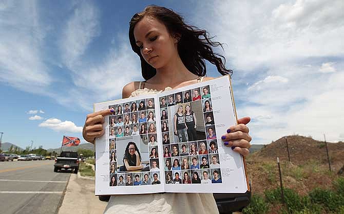 Wasatch High School sophomore Kimberly Montoya, 16, points to her altered school yearbook photo, upper left, Thursday, May 29, 2014, in Heber City, in Utah. A group of Utah high school students, including Montoya, said they were shocked and upset to discover their school yearbook photos were digitally altered, with sleeves and higher necklines drawn on to cover up bare skin.