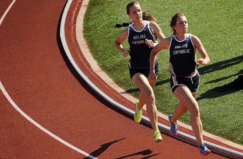 Helias teammates Kaitlyn Shea (right) and Kylie Frank battle for the top spot while pulling away from the rest of the field in the girls 1,600-meter run in action earlier this month at Adkins Stadium.