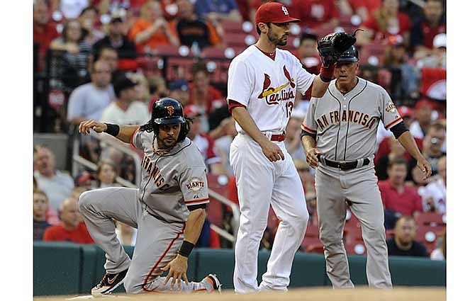 San Francisco Giants' Angel Pagan, left, slides safely into third after a fly ball hit by teammate Hunter Pence as third base coach Tim Flannery, right, and St. Louis Cardinals' Matt Carpenter (13) look on in the first inning in a baseball game on Friday, May 30, 2014, at Busch Stadium in St. Louis.