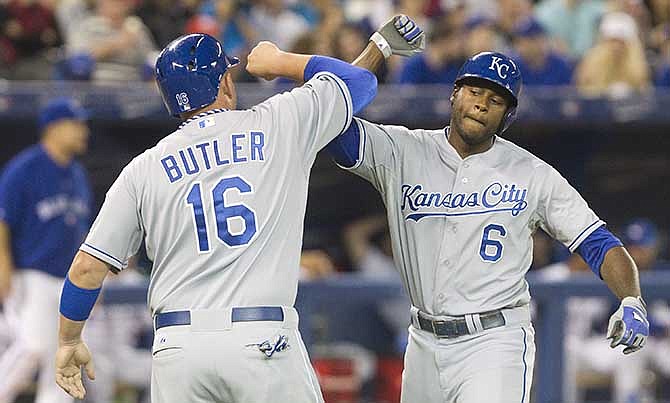 Kansas City Royals' Lorenzo Cain, right, is congratulated by Billy Butler at home plate after he drove Butler in with a two-run home run off Toronto Blue Jays starting pitcher J.A. Happ during the eighth inning of a baseball game in Toronto on Friday, May 30, 2014. 