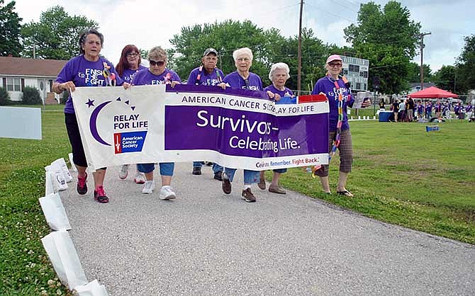 Cancer survivors and their families take the first lap to help kick off the 2014 Miller County Relay for Life on Friday, May 30, 2014, at the Eldon High School track and field. 