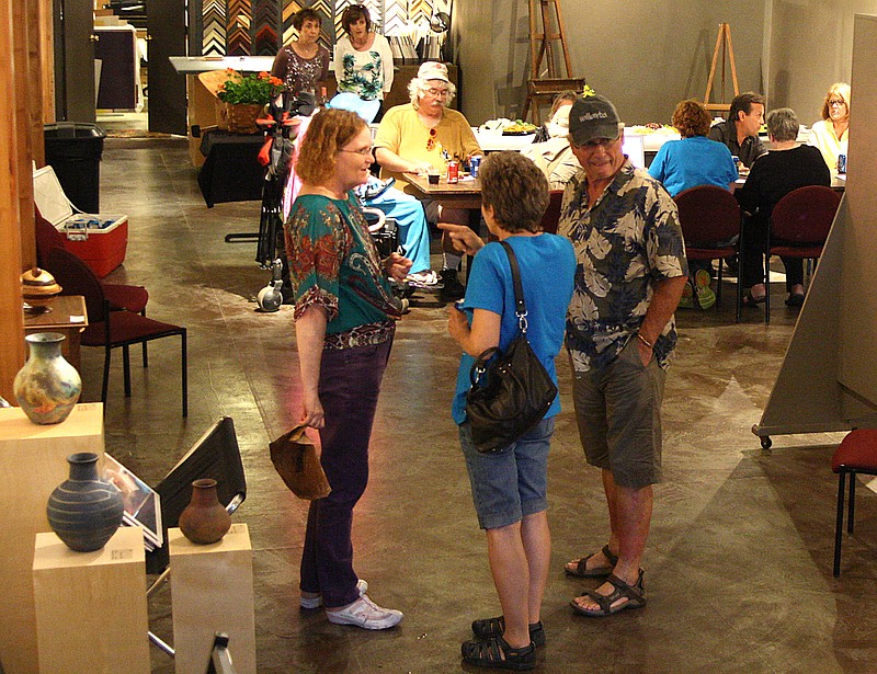 Artists and volunteers mingle during the "wet paint" reception Friday at the Art House. The Plein Air competition included 44 artists who entered 110 paintings.