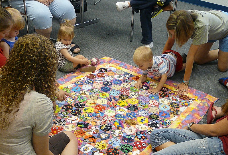 Emily Ziehmer encourages babies and toddlers to "spy" things on the quilt during the summer reading program.