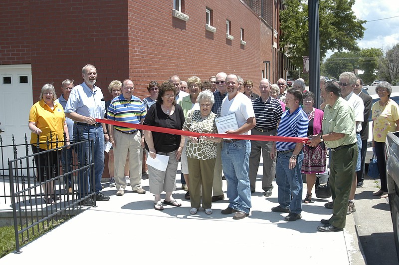 Surrounded by many of the people whose efforts led to the new building, Betty Williamson cuts the ribbon for the new Genealogy Library annex of the Moniteau County Historical Society. Williamson is one of the original members of the historical society. The event was held Saturday, May 31.