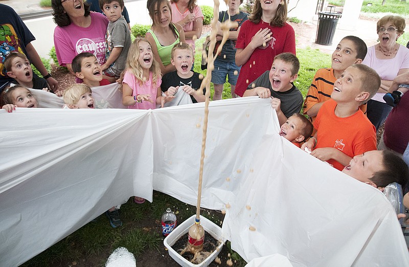 Children show their excitement after Mentos were dropped into a liter of Coca Cola causing a chemical reaction Wednesday for the Callaway County Library's Mad Scientist Lab program. The event designed for ages 5 and older allowed children to experiment with liquids, solids and sound.