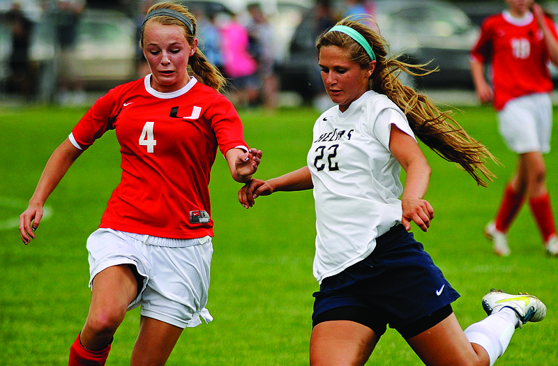 Maddie Lammers of Helias sends a pass just in front of Union defender MacKenzie Kiewitt during a sectional game last month at the 179 Soccer Park.