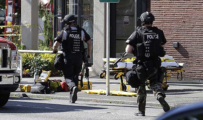 Seattle Police SWAT officers run toward a campus building following a shooting at Seattle Pacific University on Thursday, June 5, 2014, in Seattle.
