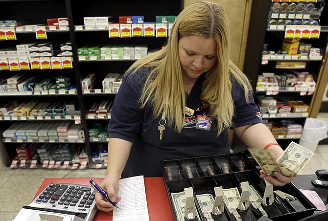 Amy Jennewein reconciles a cash register drawer during her shift at a grocery store in House Springs.