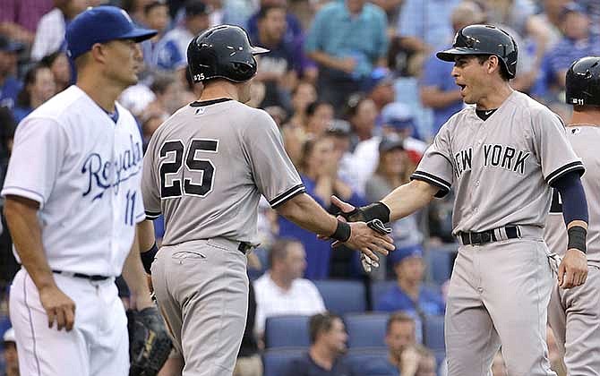 New York Yankees' Mark Teixeira (25) and Jacoby Ellsbury, right, celebrate while Kansas City Royals starting pitcher Jeremy Guthrie, left, walks back to the mound after they scored on a three-run double by Brian McCann during the third inning of a baseball game Friday, June 6, 2014, in Kansas City, Mo. 